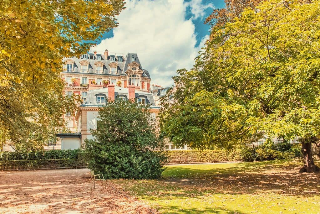 A park with trees and a building in the background.