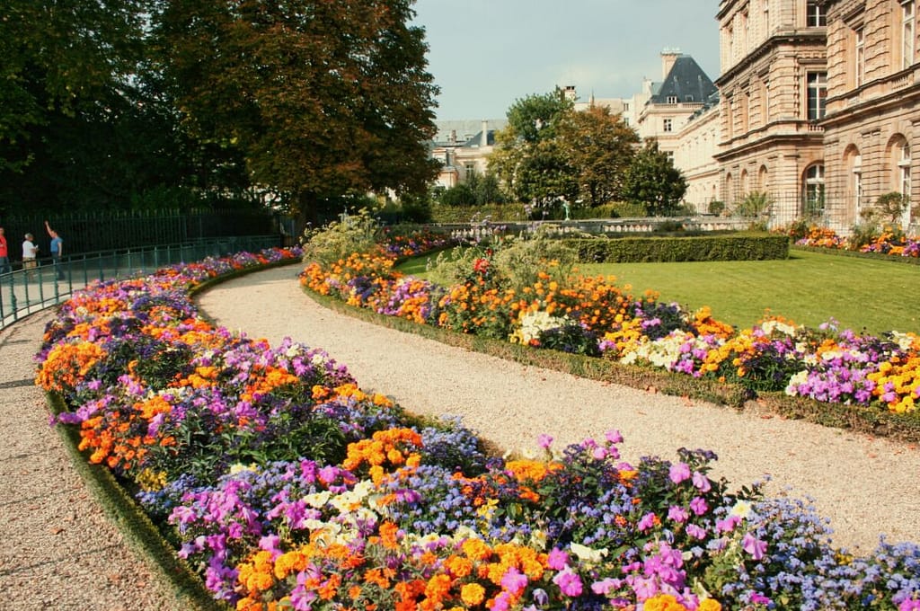 A pathway with colorful flowers in front of a building.