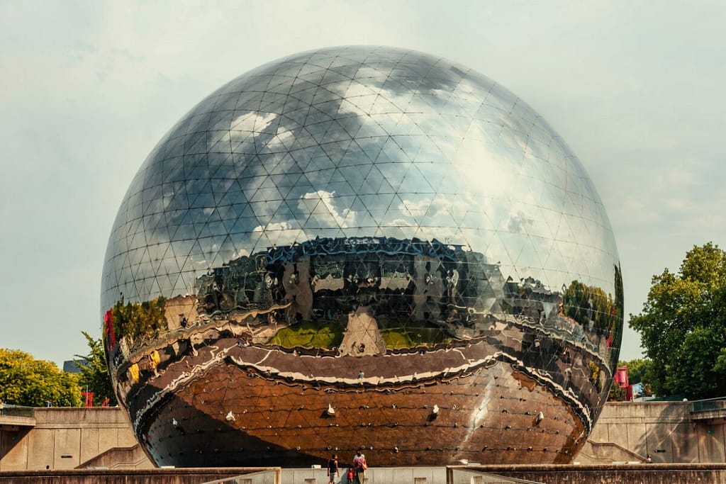 A large mirrored ball in front of a building.