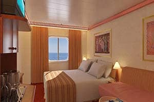 A bedroom on a cruise ship with a bed and a chair.