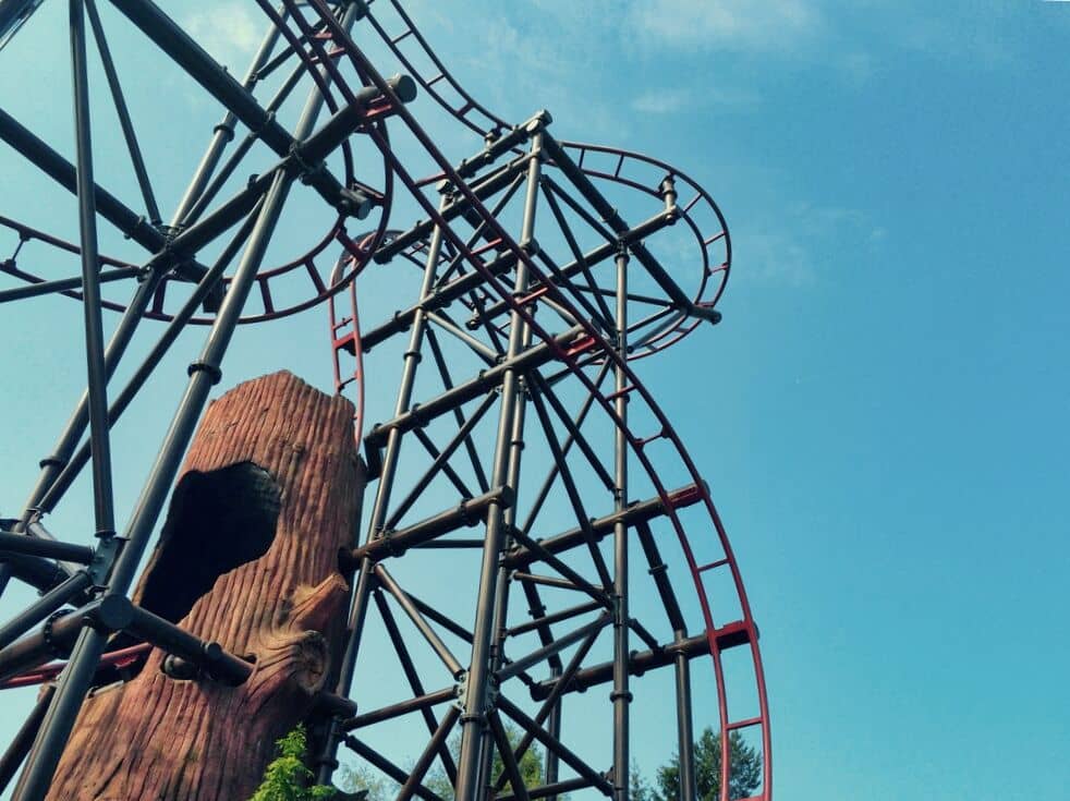 A roller coaster with a tree in the background.